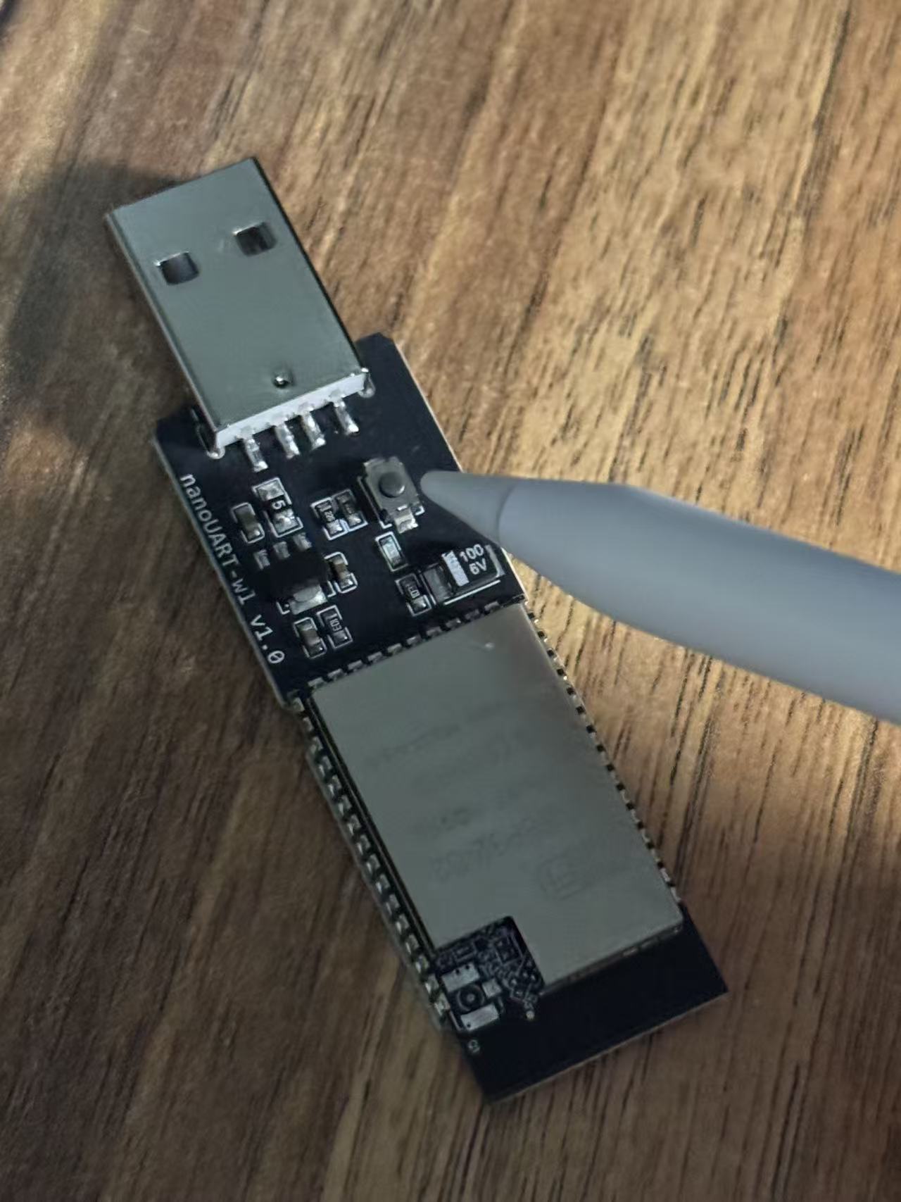 笔尖指向 ESP32-S2 板上的按钮